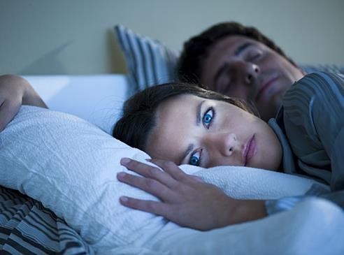 Professionelle Hilfe in Niddatal bei Schlafstörungen durch Rosemarie Christensen, Heilpraktikerin Psychotherapie Junge Frau liegt schlaflos im Bett